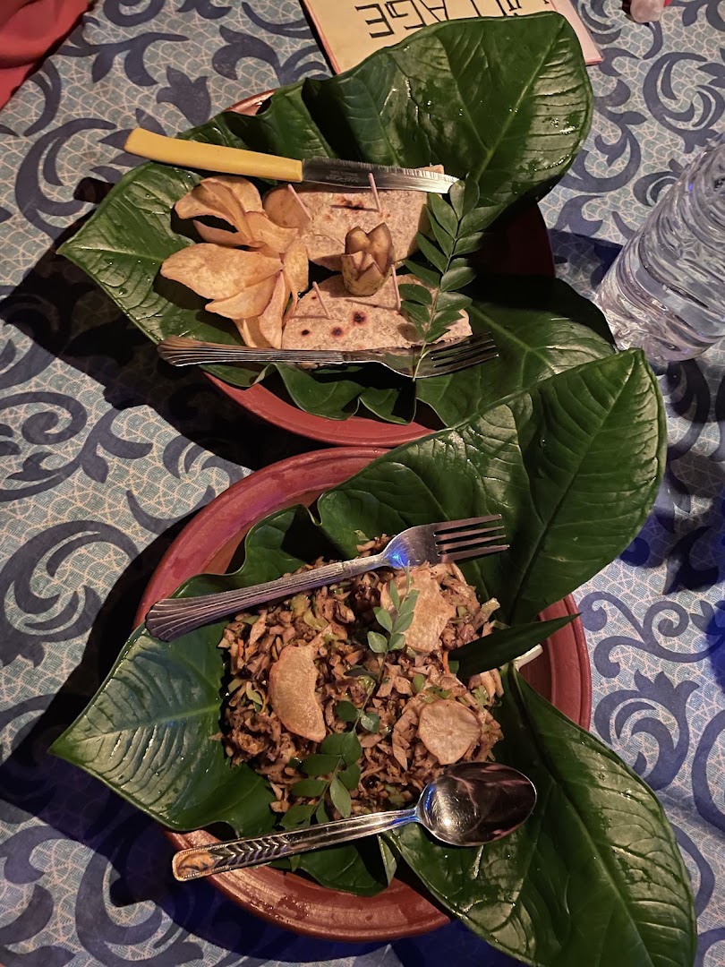 Kottu and accompaniments served on green leaves in clay plates