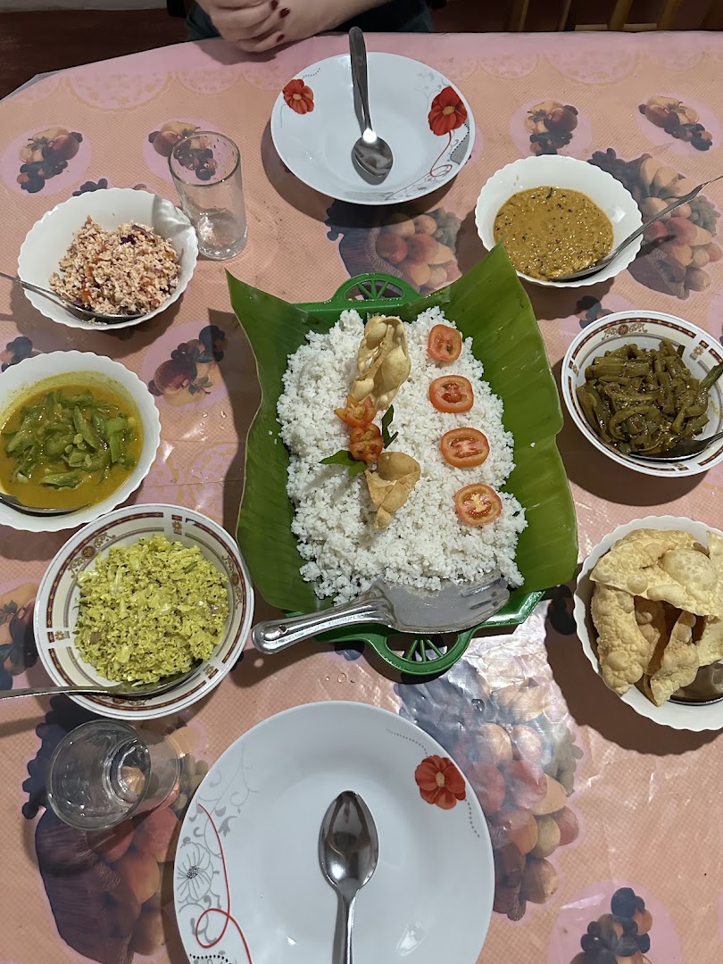 Rice and Sri Lankan side dishes arranged around a banana leaf platter