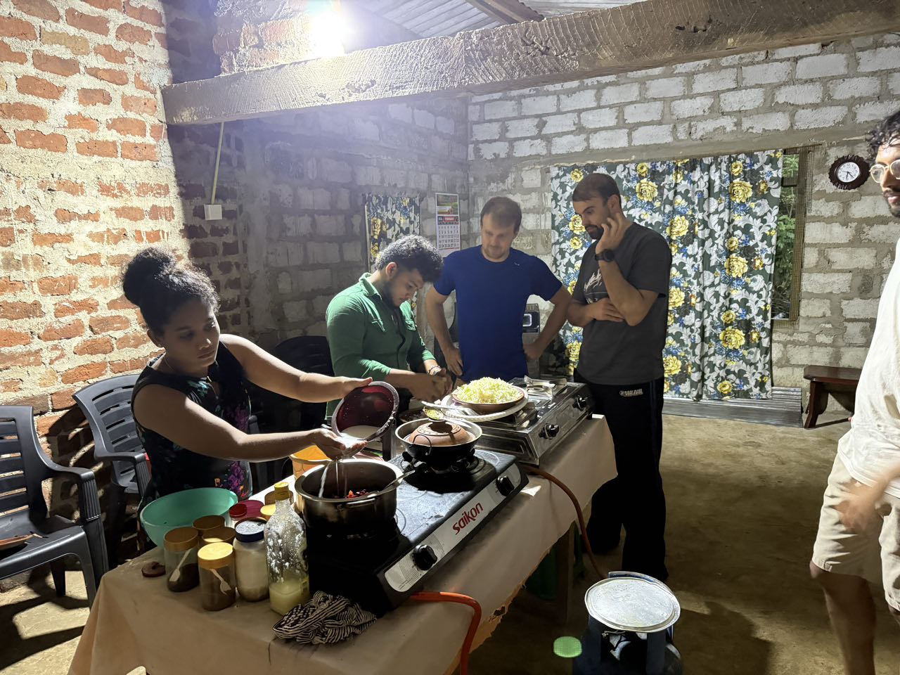 Cooking demonstration with clay pots, spices, and visitors gathered around